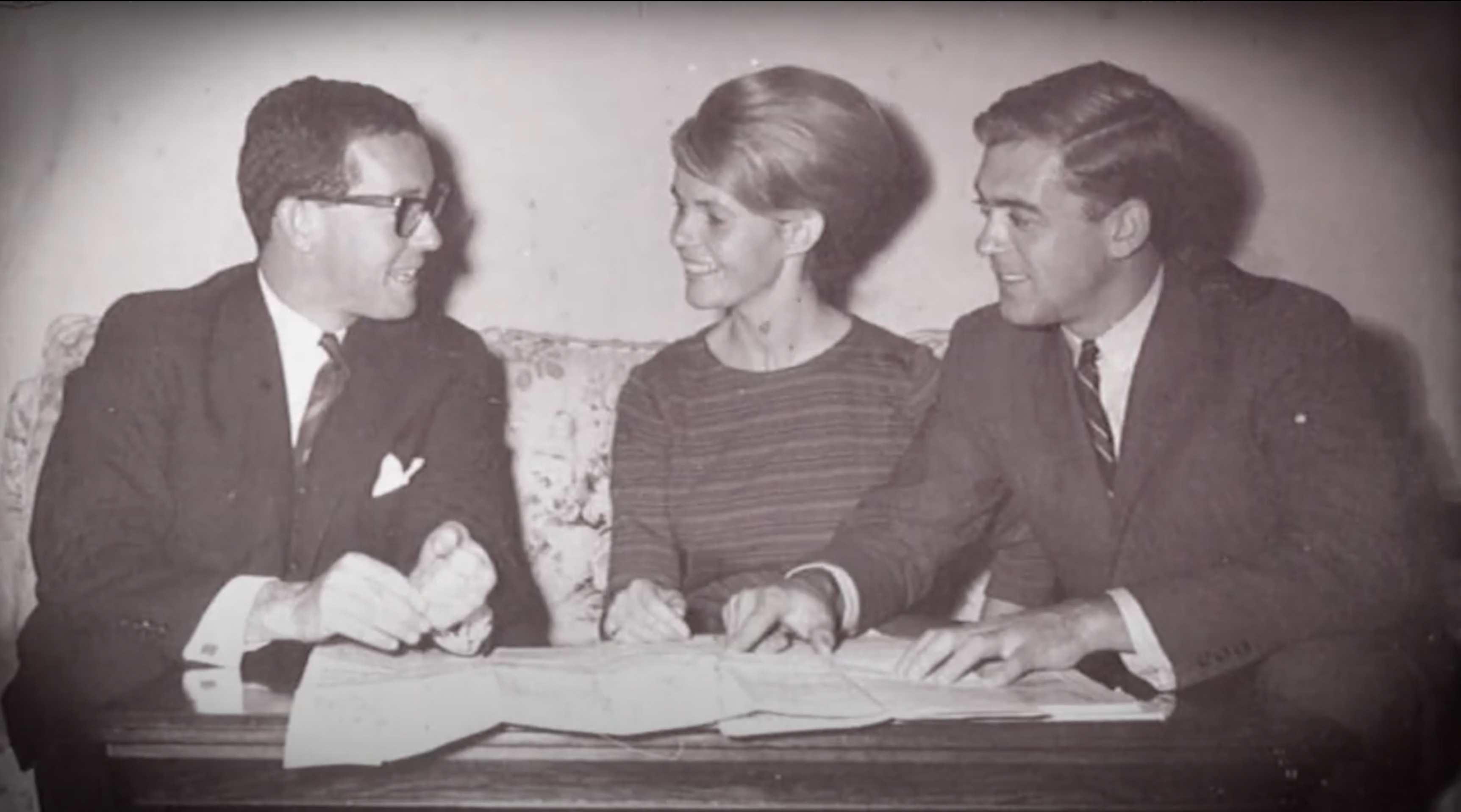 Butterfield and Robinson founders George Butterfield, Martha Butterfield and Sidney Robinson gathered around a map in the 1960s
