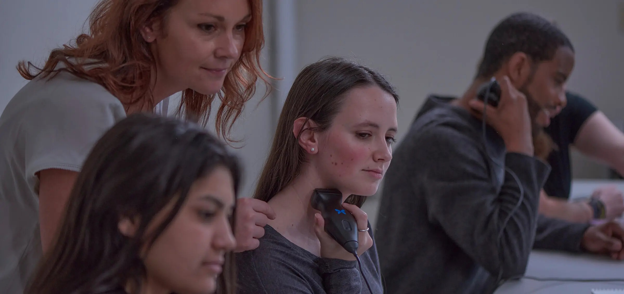 Learners practicing ultrasound with a Butterfly probe and viewing images on a tablet