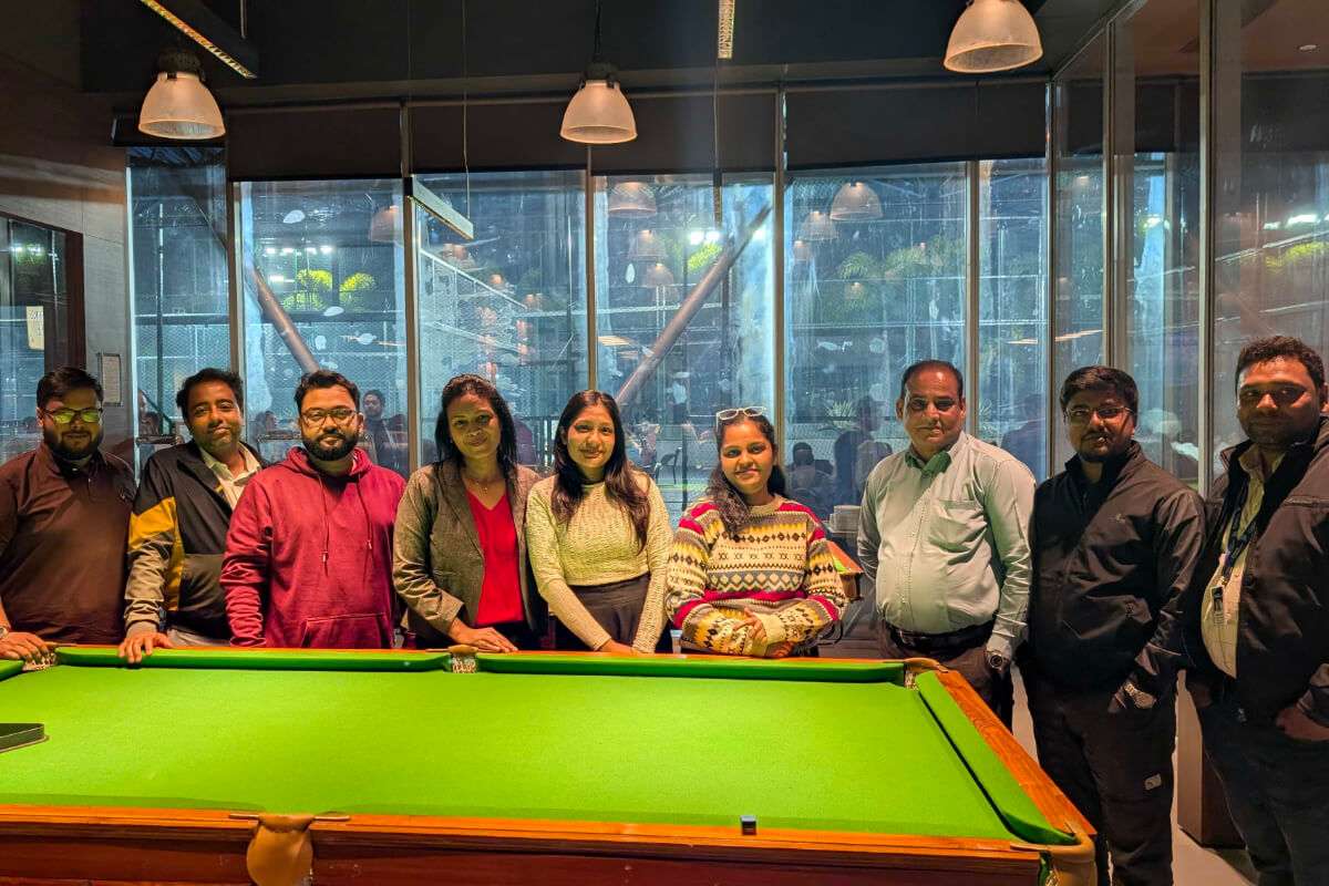 Nine BuyerForesight colleagues standing behind a billiards table