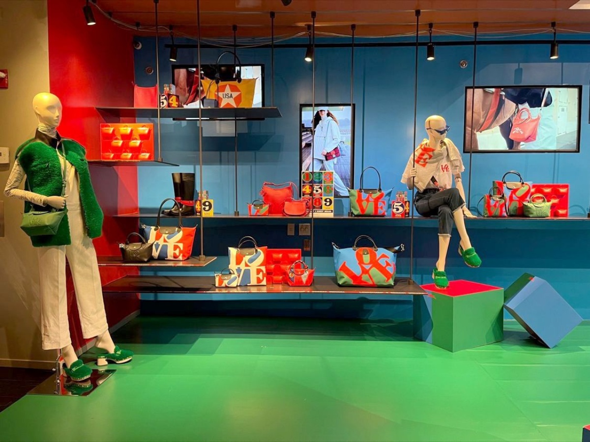 Longchamp store window with colorful bags, mannequins and layered graphic panels