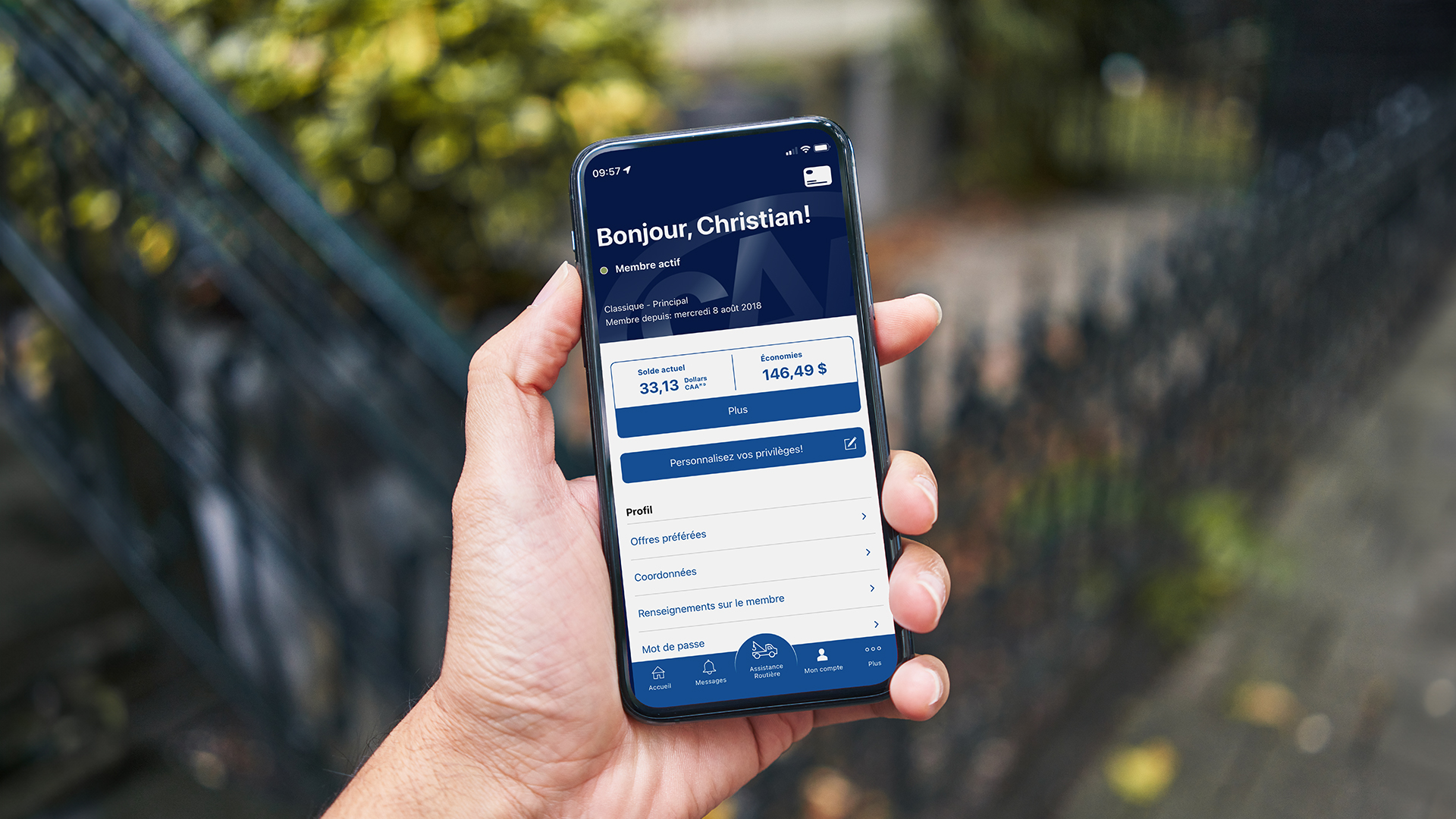 A person holds a phone displaying the CAA Mobile member account