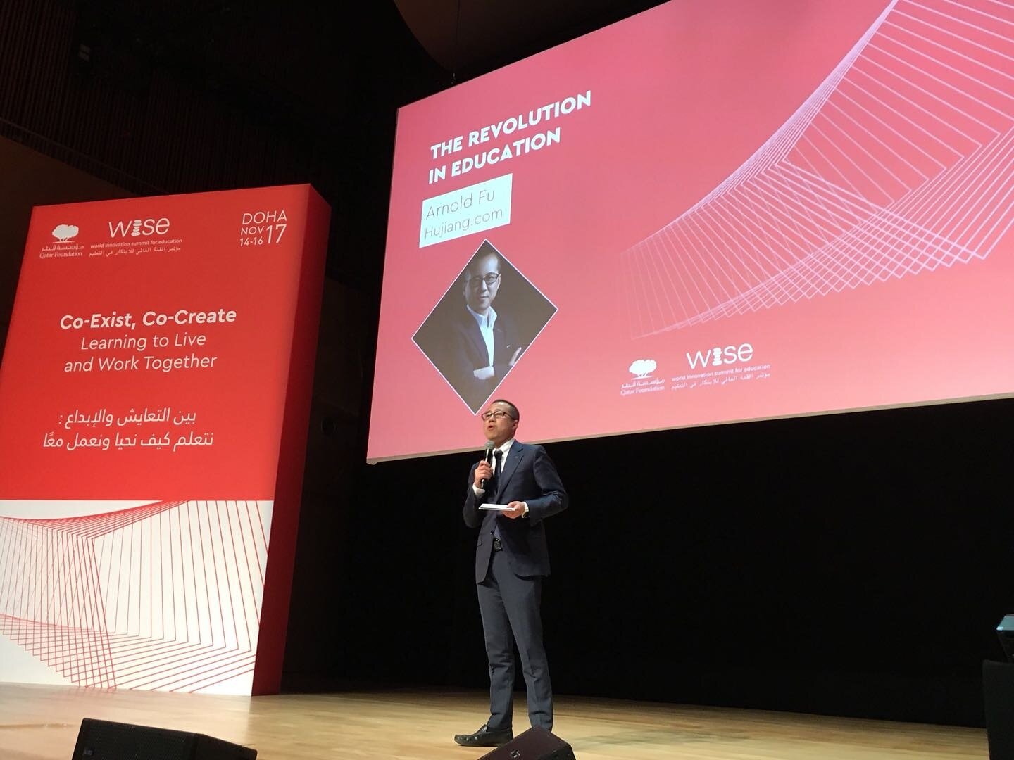 Cairui Fu speaks on stage at WISE 2017 in Doha beneath a slide titled The Revolution in Education