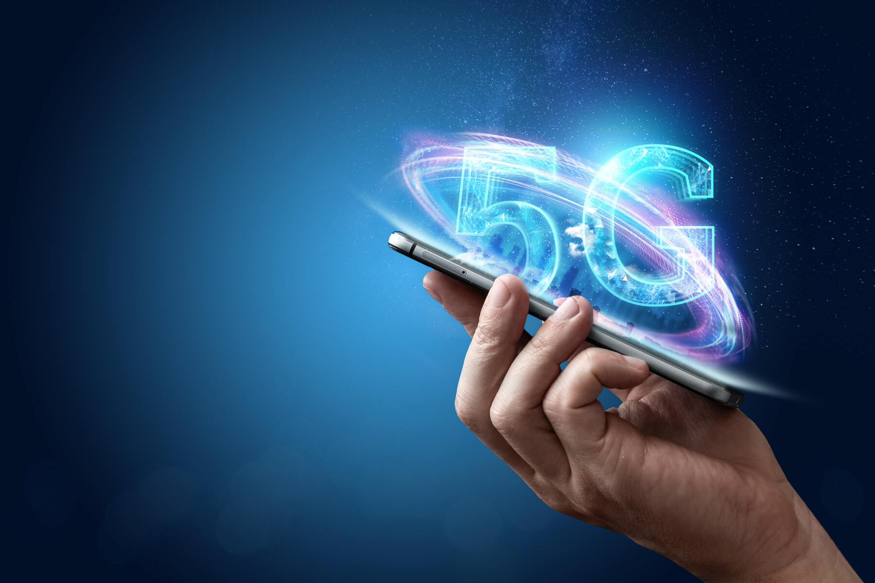 A hand holding a phone beneath a glowing 5G graphic