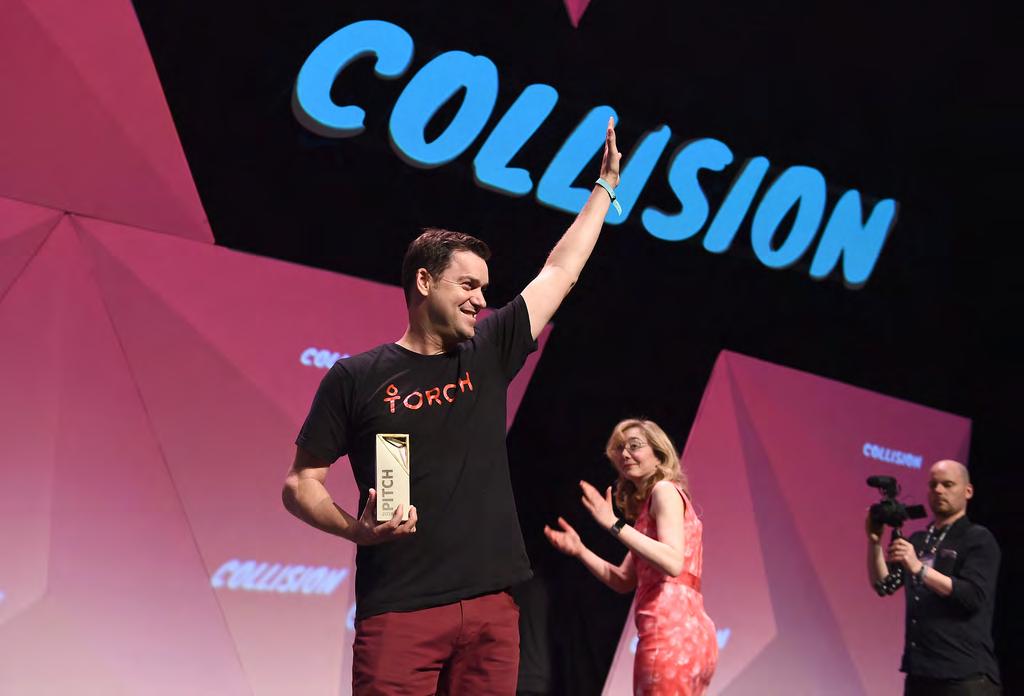 Cameron Yarbrough raises a hand on the Collision stage while holding the PITCH trophy.