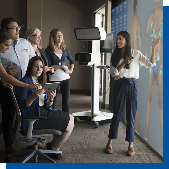 Canfield clinical-services staff discussing medical images beside an imaging system