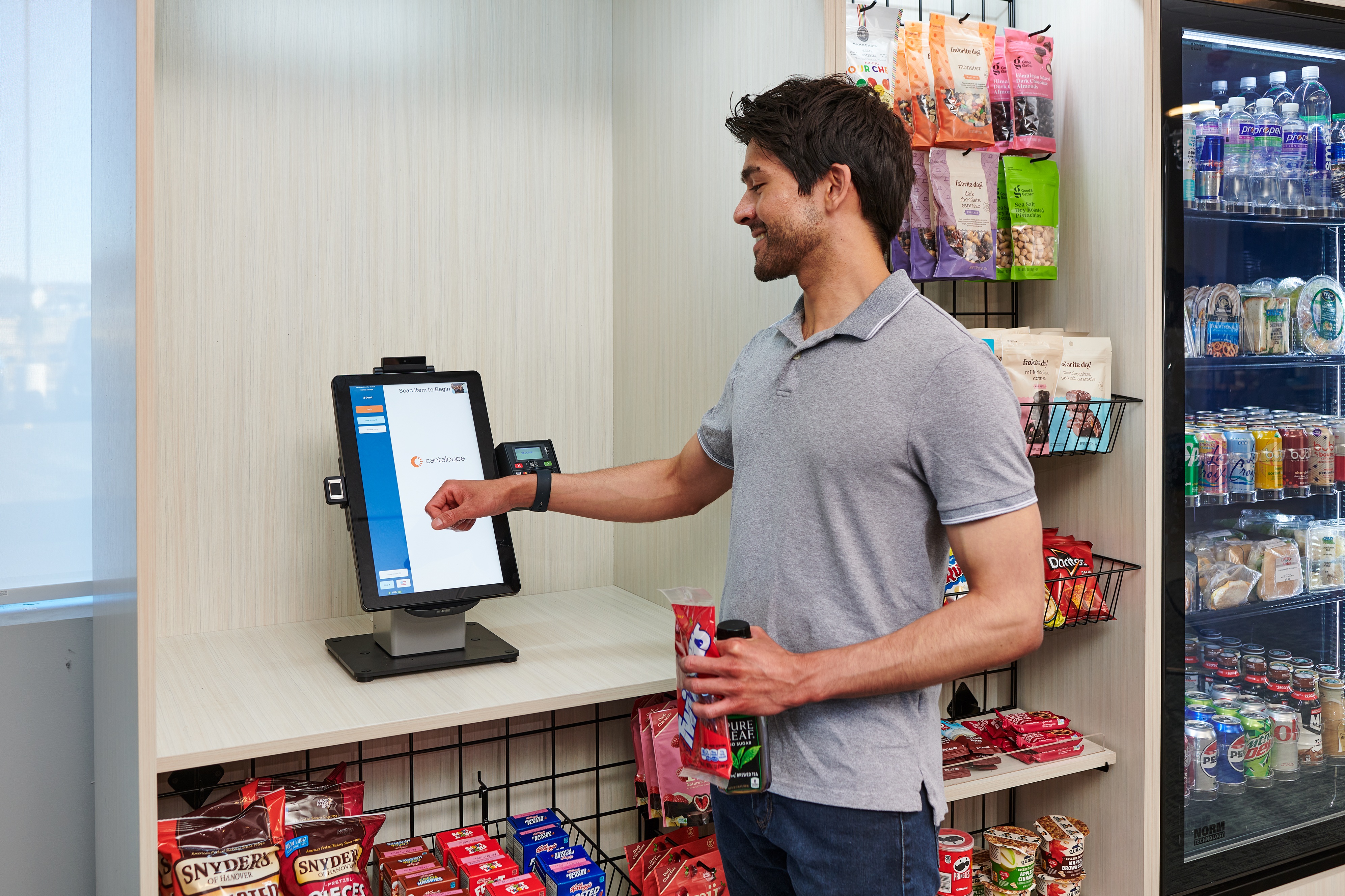 A shopper pays with a smartwatch at a Cantaloupe micro-market checkout