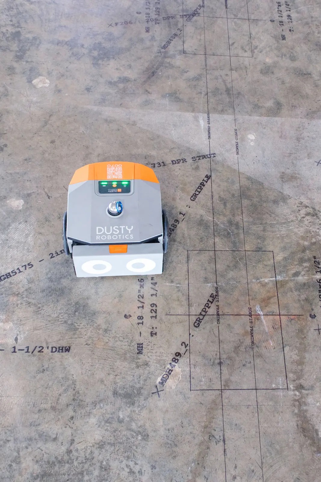 Dusty Robotics FieldPrinter surrounded by printed construction layout lines on a concrete floor