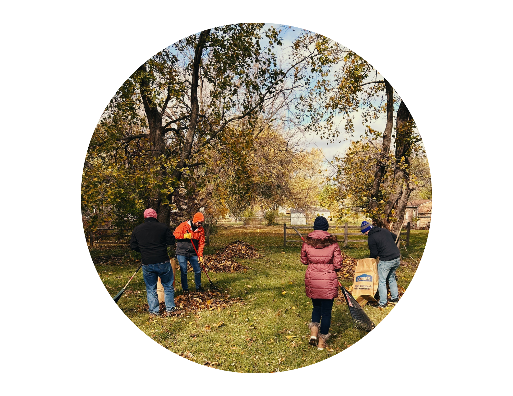 CAPITAL Cares volunteers raking and bagging leaves in a yard