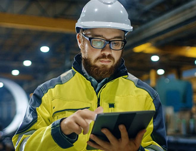 Illustrative warehouse worker consulting a tablet, from Capstone’s website