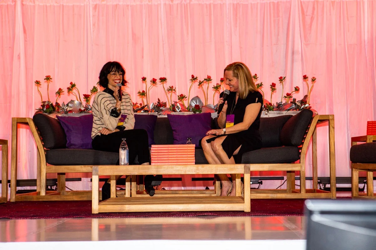 Cara Federici and Christine Magrann speaking together on a conference stage