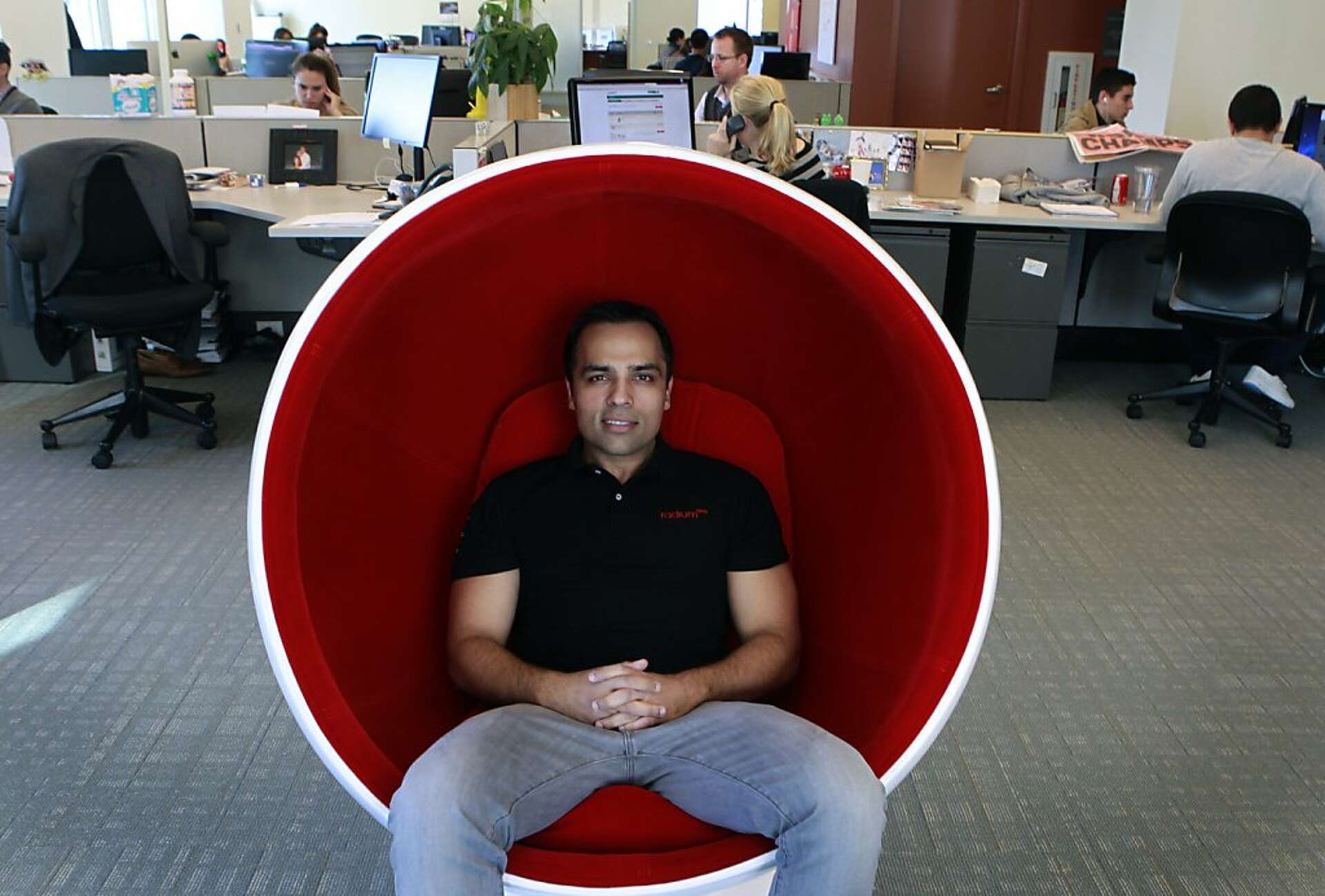 RadiumOne founder Gurbaksh Chahal seated in a red chair in the company's San Francisco office