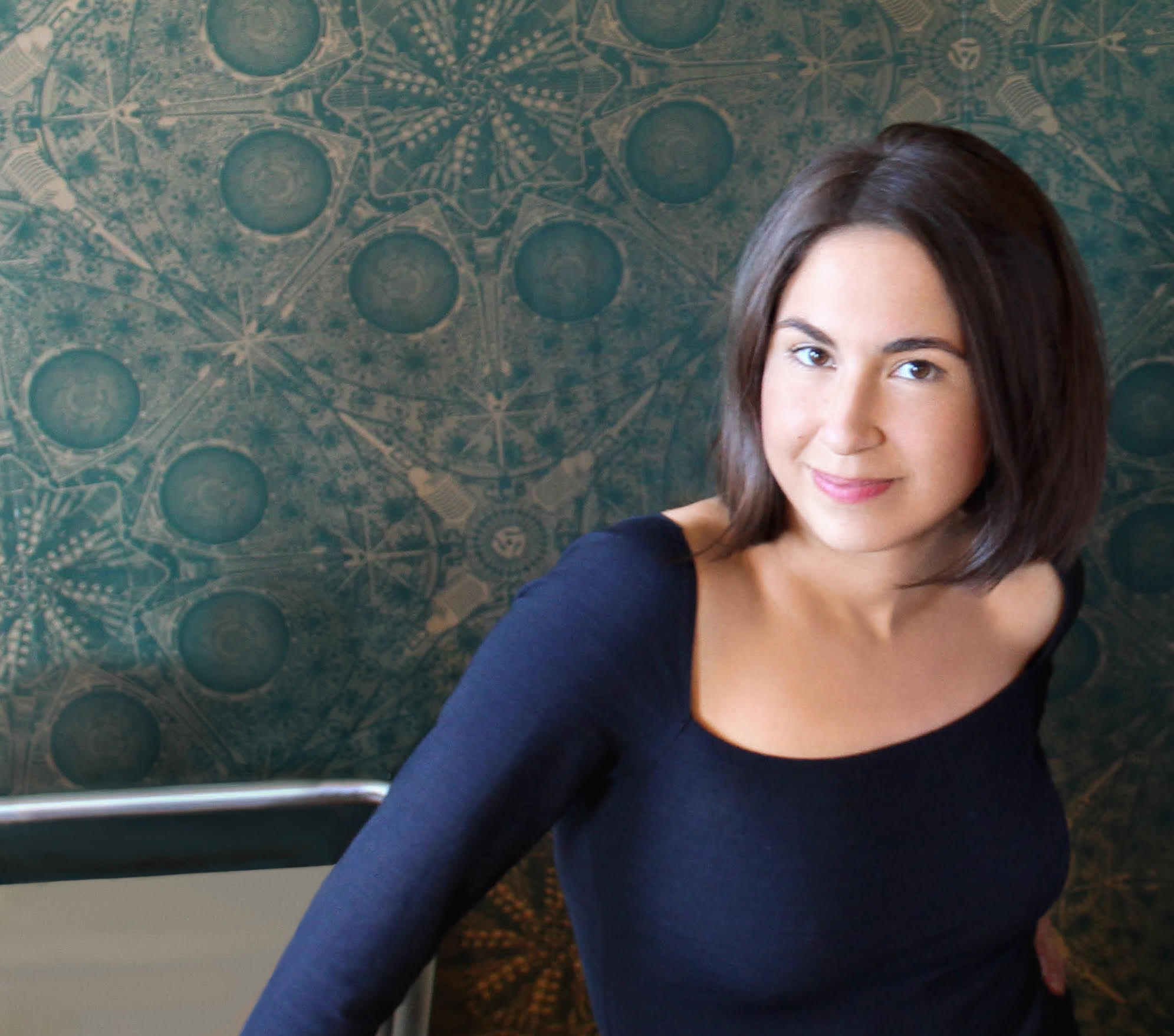 Caretaker co-founder Susannah Vila seated against a patterned green wall