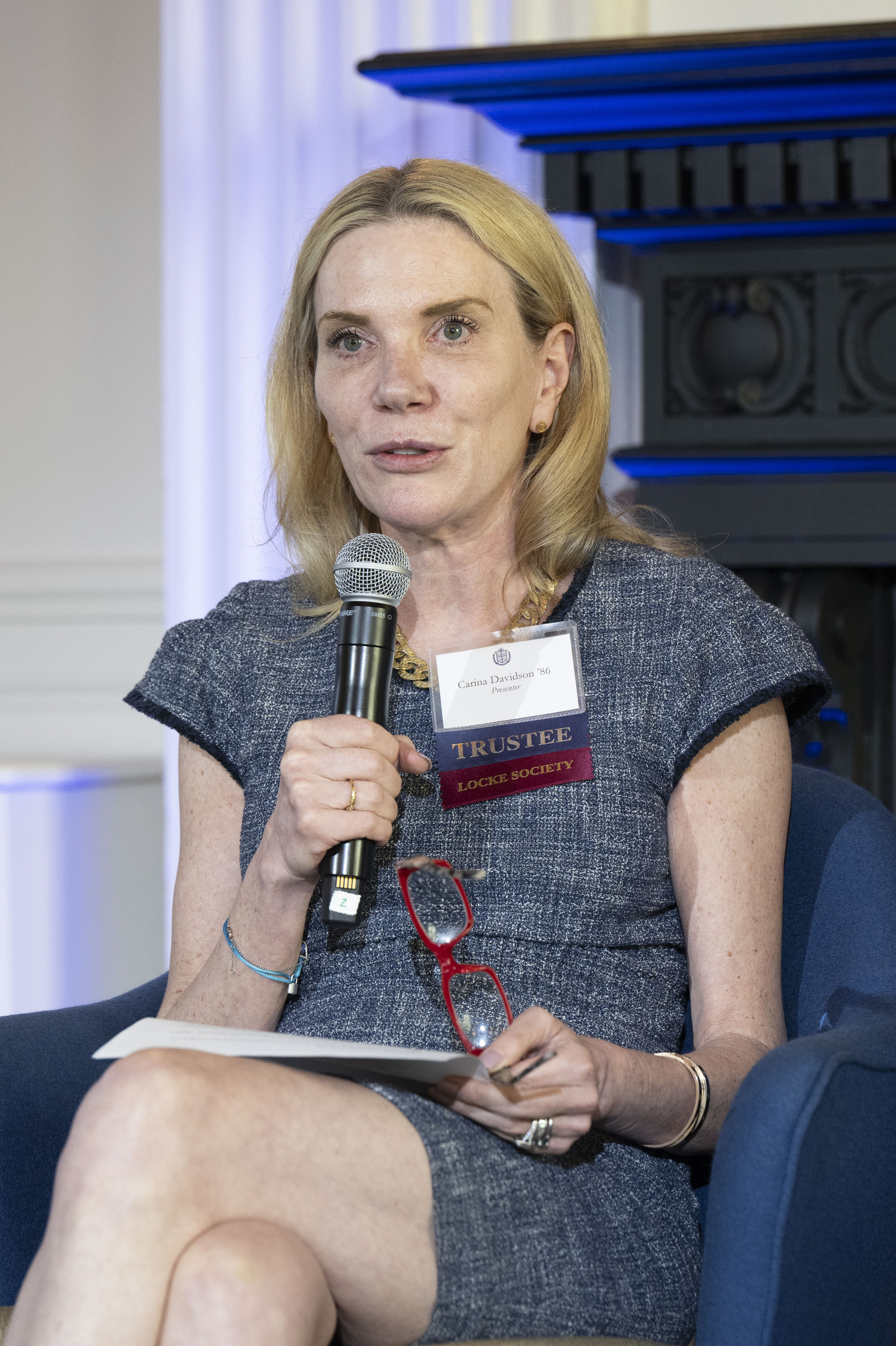 Carina Davidson speaking into a microphone at the Locke Society event