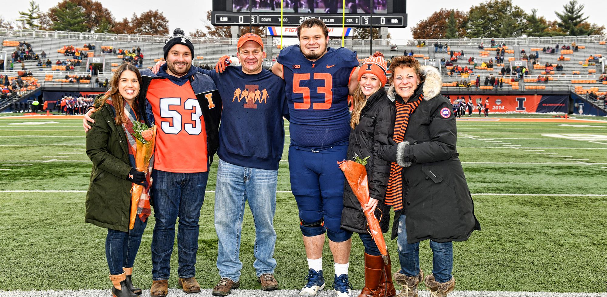 Carl Allegretti and his family with Illinois football player Nick Allegretti on the field