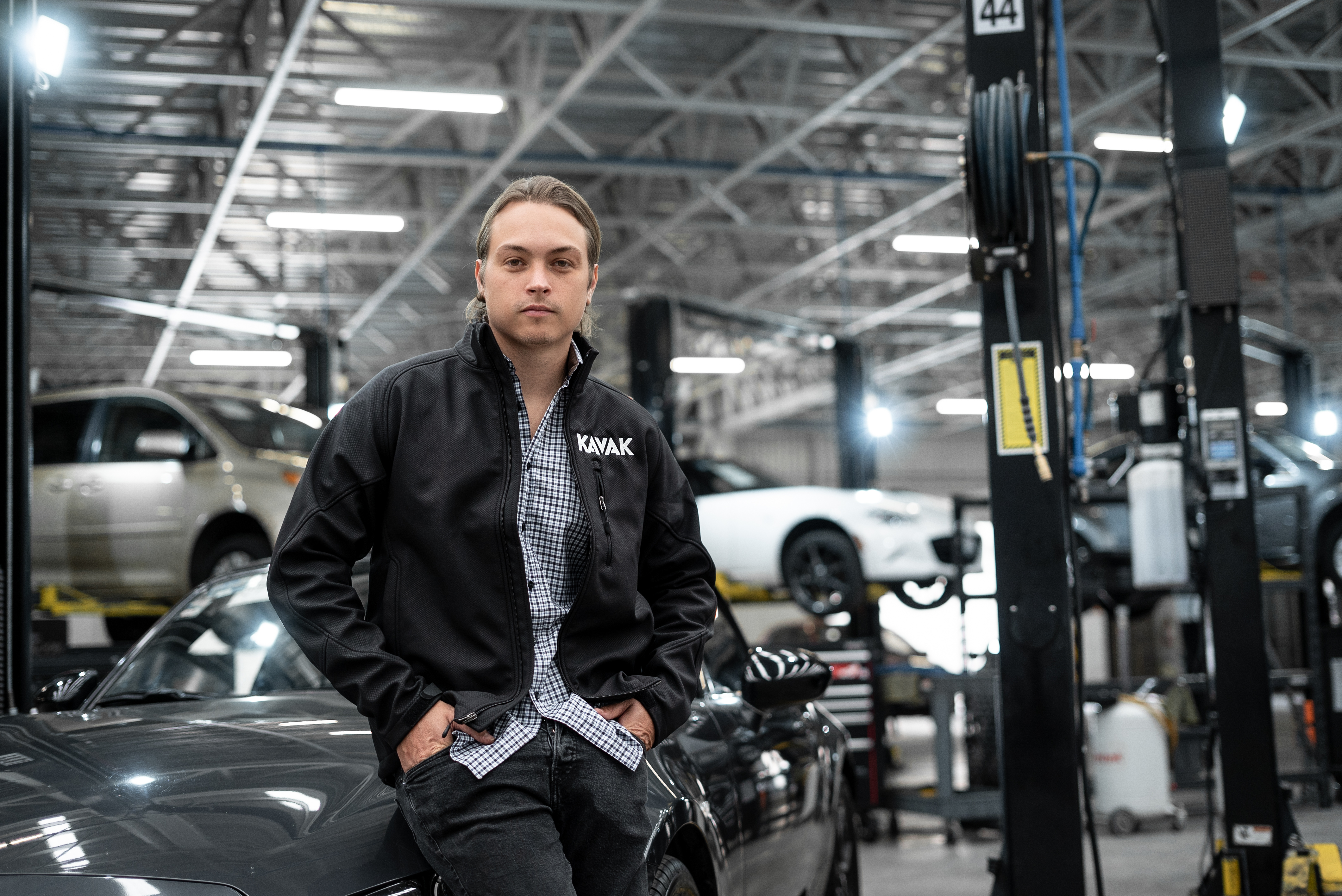 Carlos García Ottati standing beside a car inside a Kavak workshop