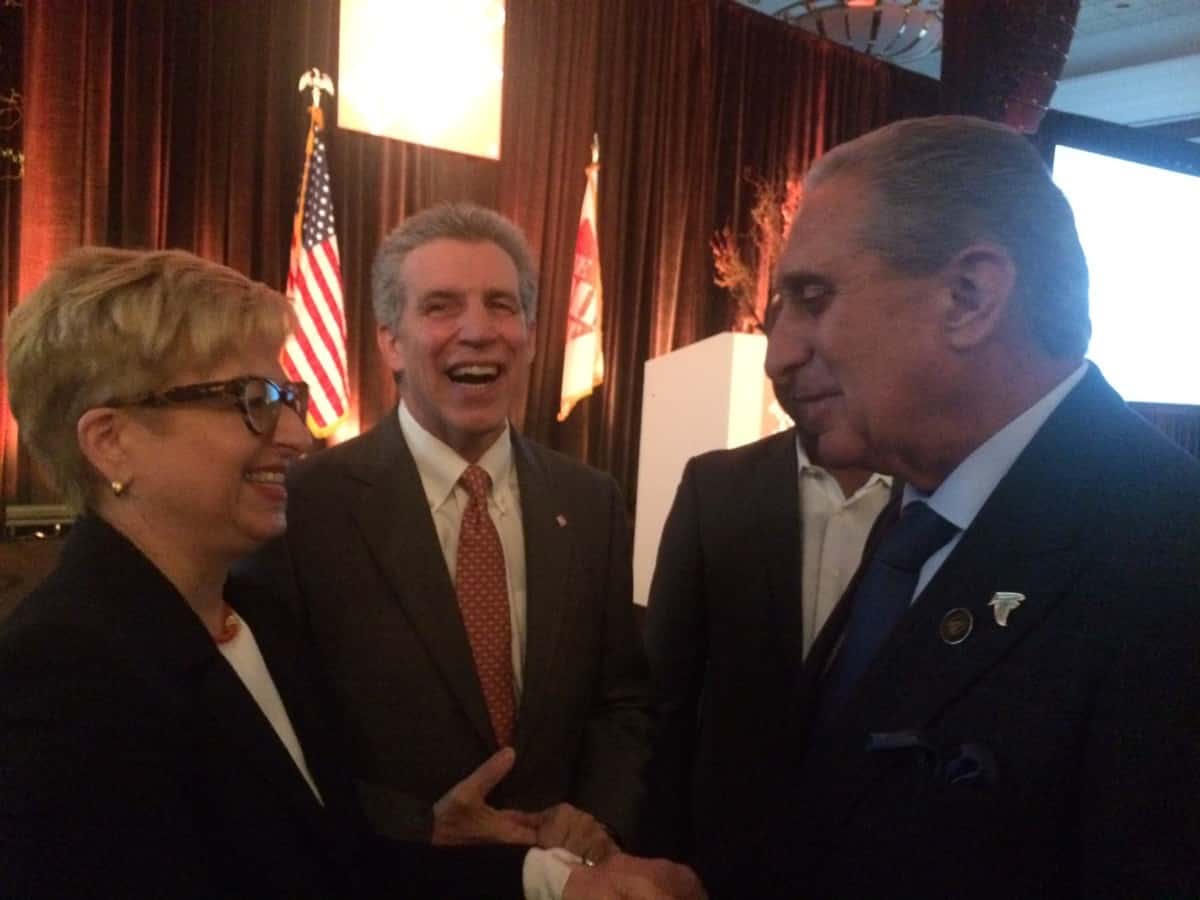 Carol Tomé speaking with Arthur Blank, with Craig Menear between them, at Home Depot’s 2016 annual meeting