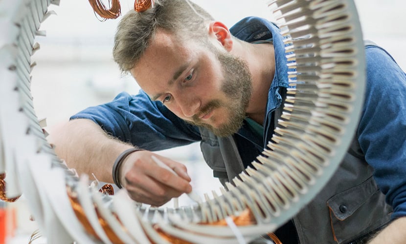 A technician working inside a circular electromagnetic assembly