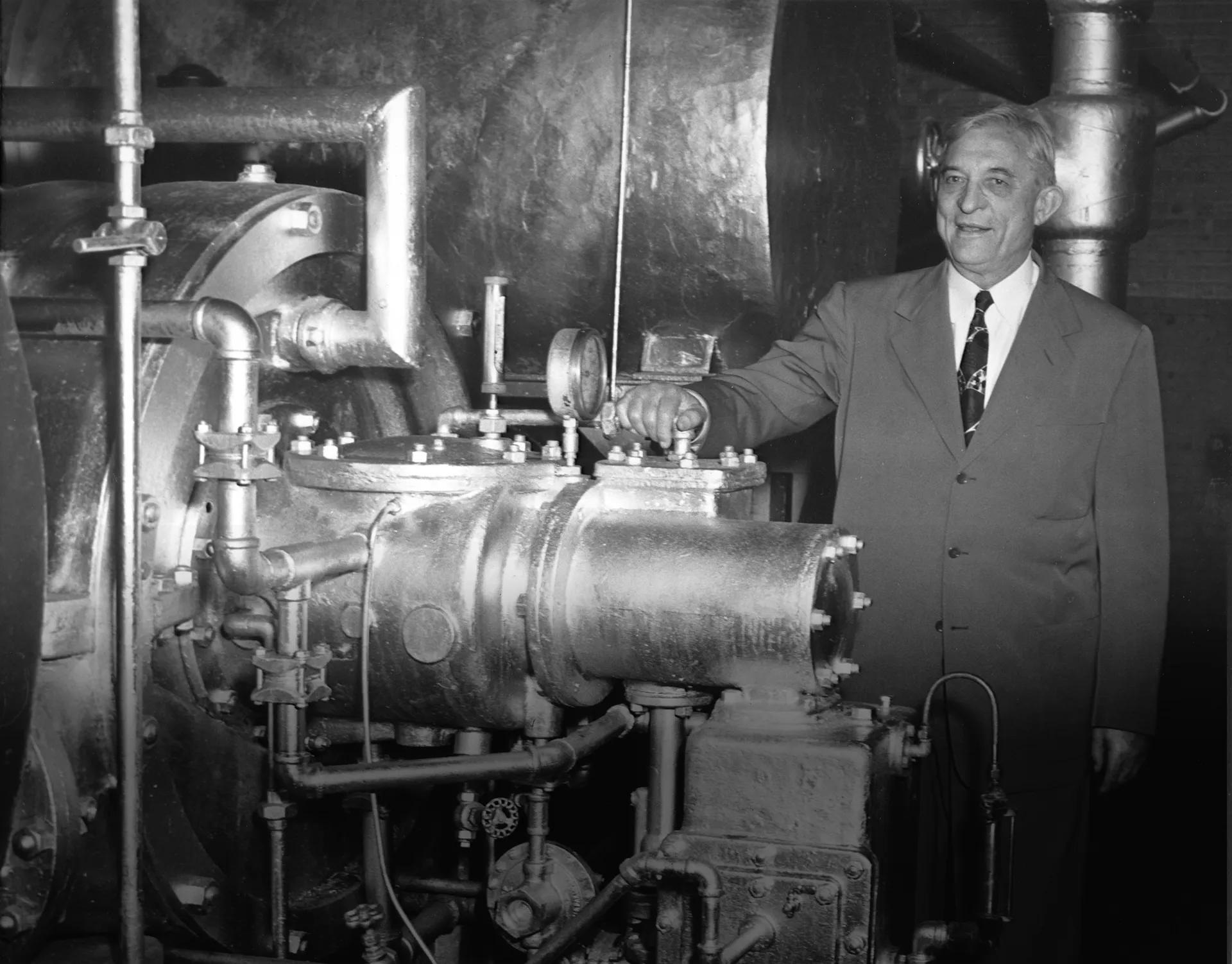 Willis Carrier standing beside a centrifugal refrigeration machine