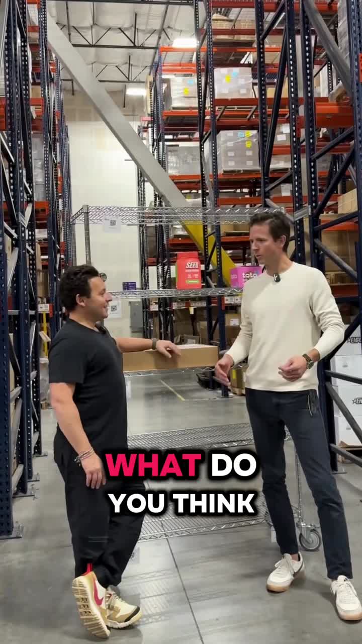 Casey Armstrong and Shopify president Harley Finkelstein talking in a warehouse aisle