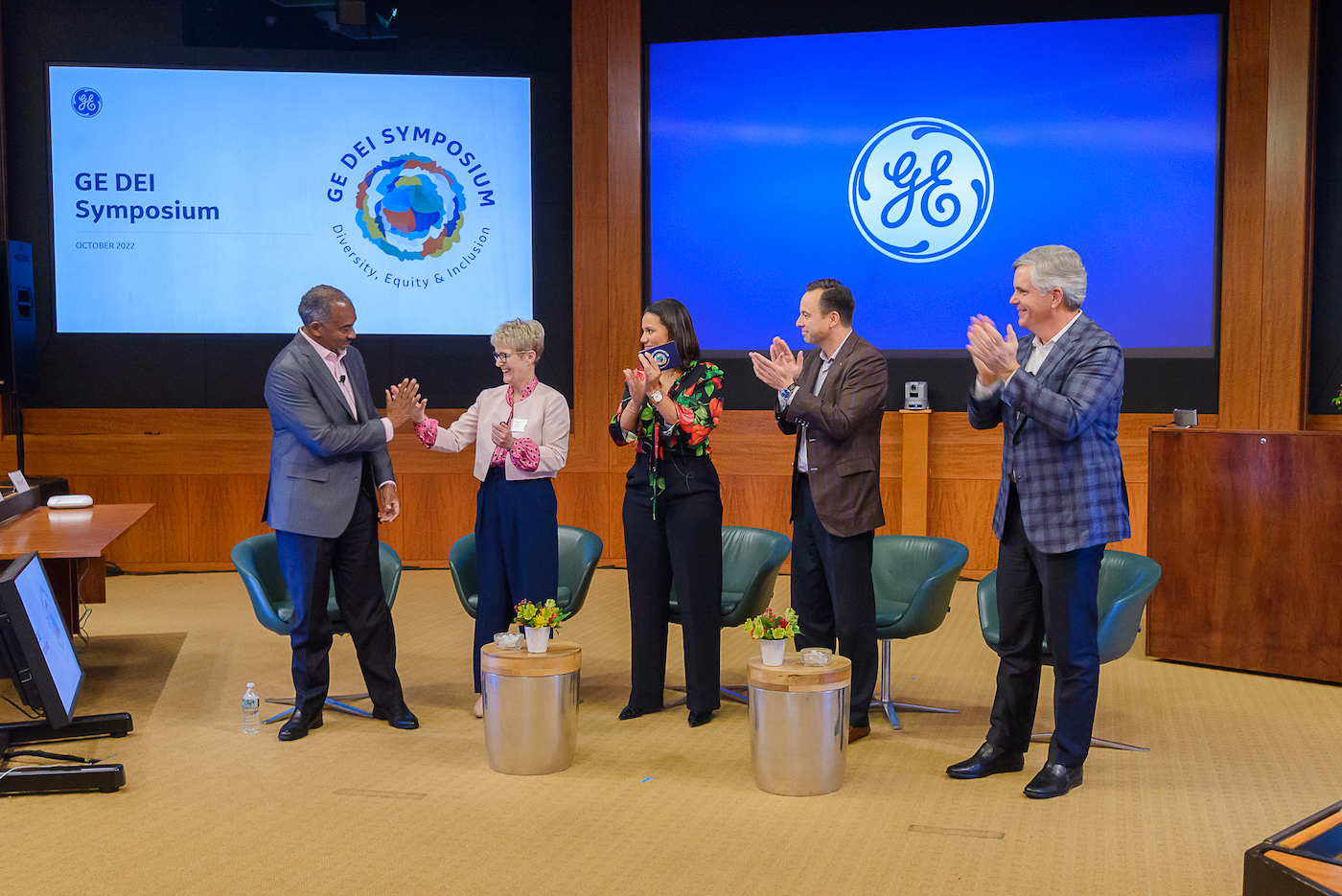 Catherine Estrampes, second from left, congratulates Colin Parris onstage with GE colleagues at Crotonville in October 2022.