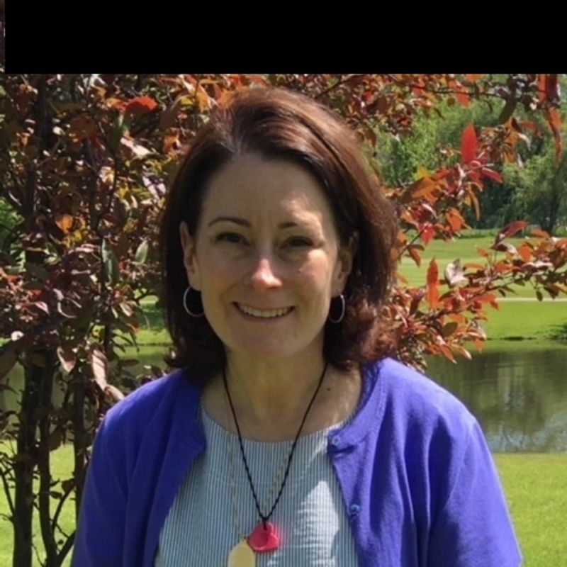 Catherine Riedel outdoors beside a tree and pond