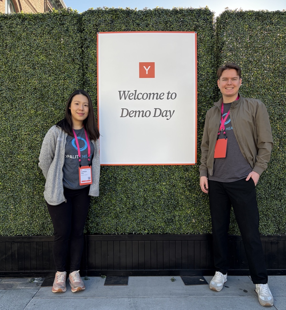 Cathleen Kuo and Alex Mehregan standing beside a Y Combinator Demo Day sign