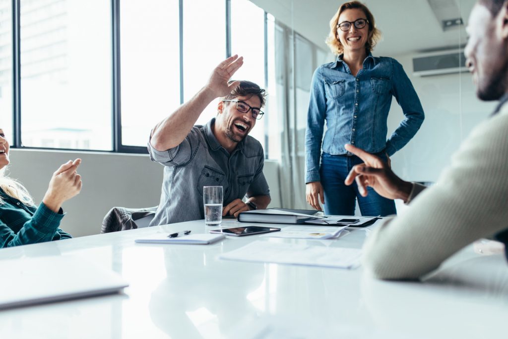 A group in a bright meeting room having an animated discussion