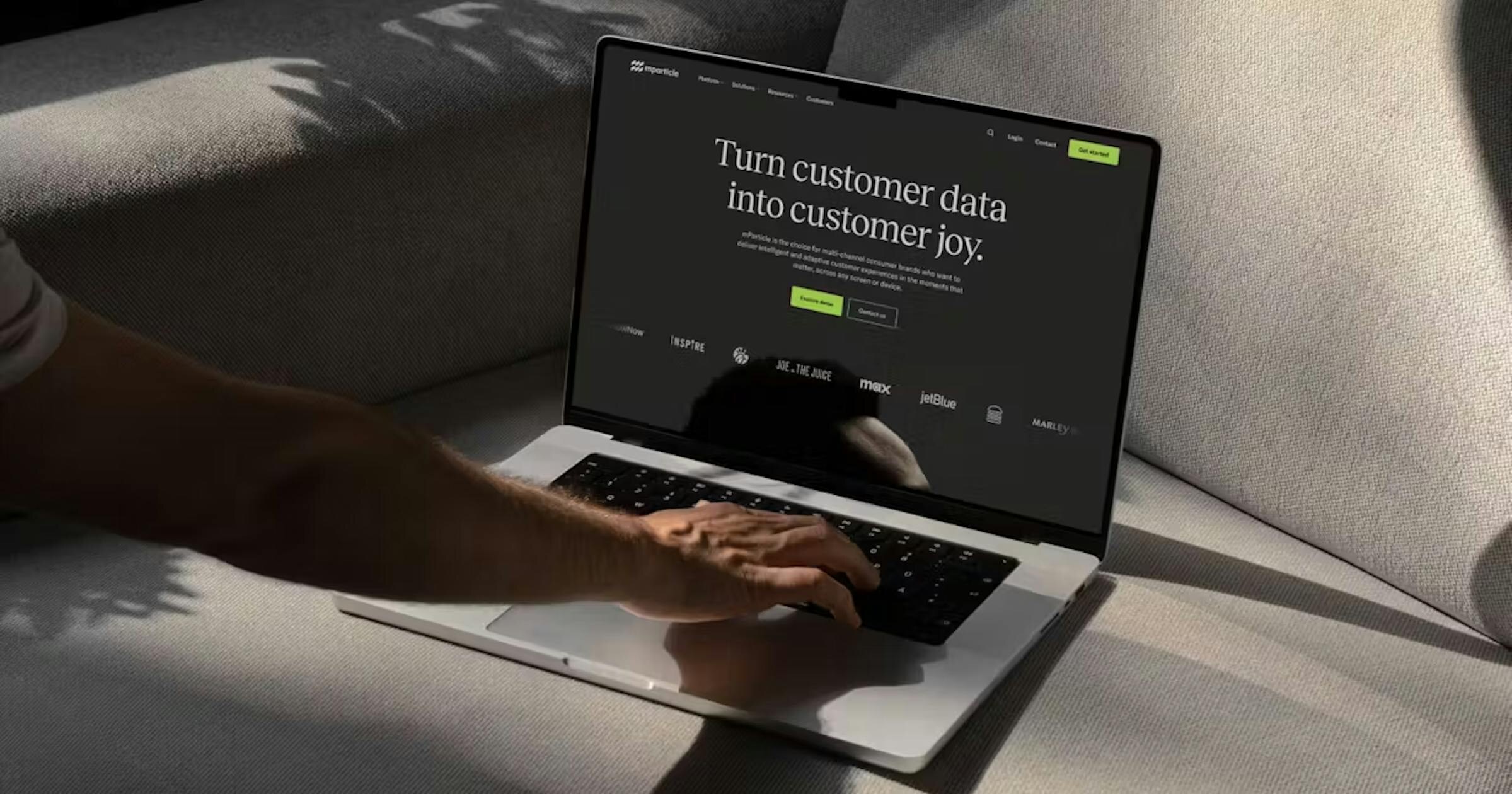 Laptop displaying the mParticle customer data platform website in a softly lit room