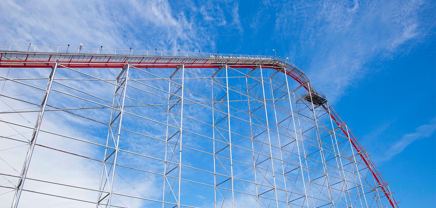 Magnum XL-200’s red track and white supports rise above Cedar Point under a blue sky
