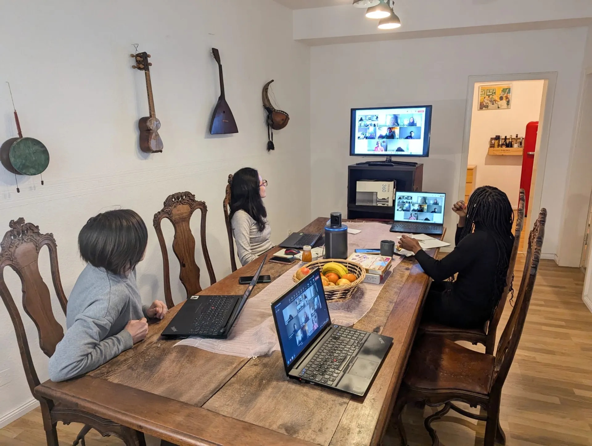 CEFE team members sit around a table while remote colleagues join on screens