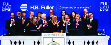 Celeste Mastin and H.B. Fuller colleagues on the New York Stock Exchange closing bell podium