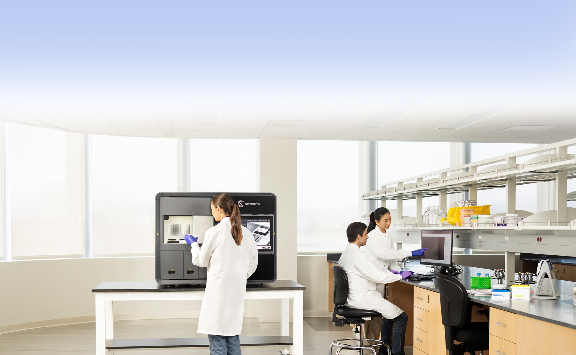 Scientists working beside a Cellanome R3200 instrument in a laboratory