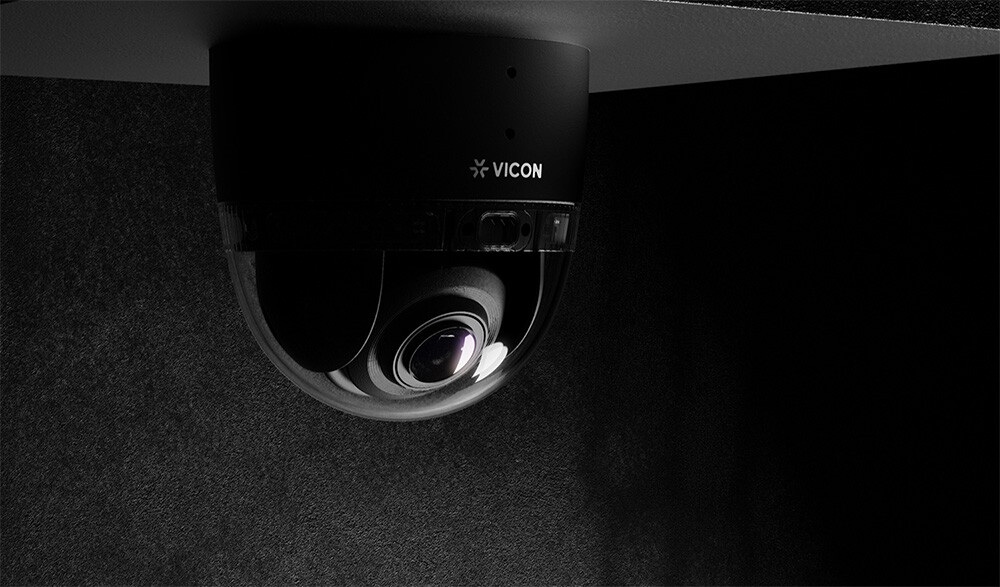 Black Vicon NEXT dome security camera mounted beneath a ceiling