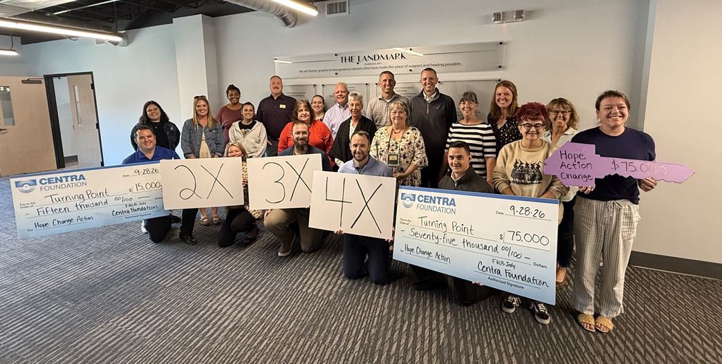 Centra Foundation and Turning Point representatives hold presentation checks for the shelter repair grants
