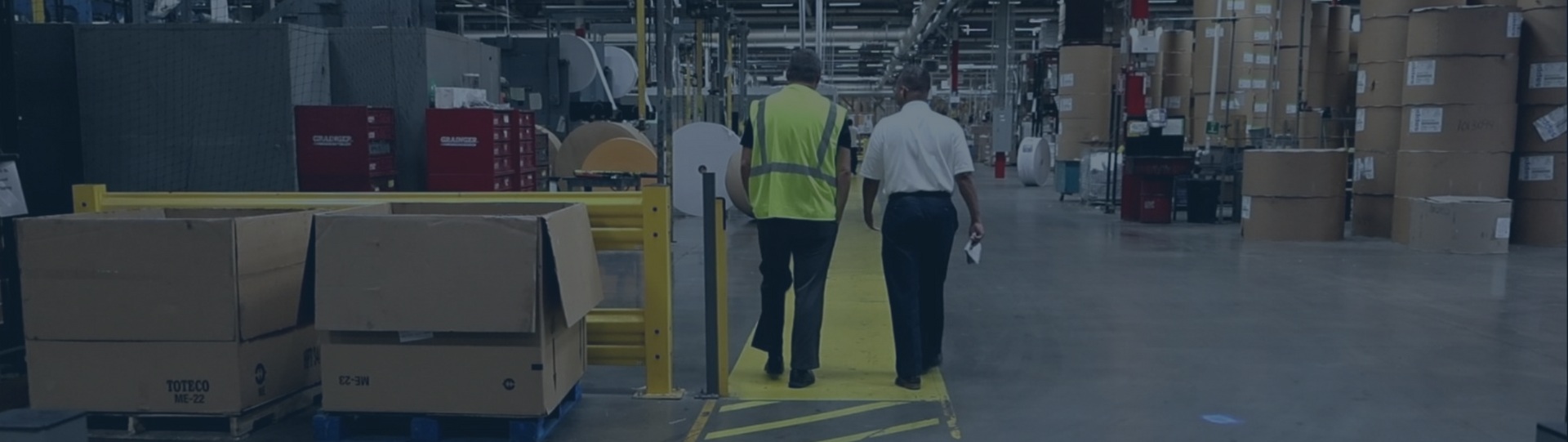 Two Cenveo employees walking through an envelope manufacturing plant