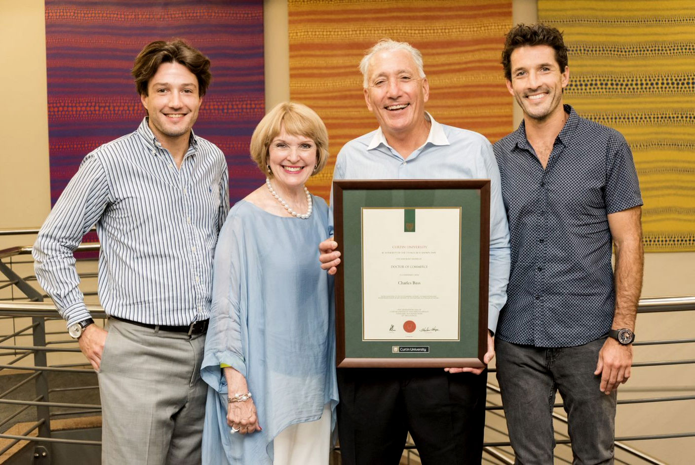 Charlie Bass with members of the Bass family, holding a framed university award