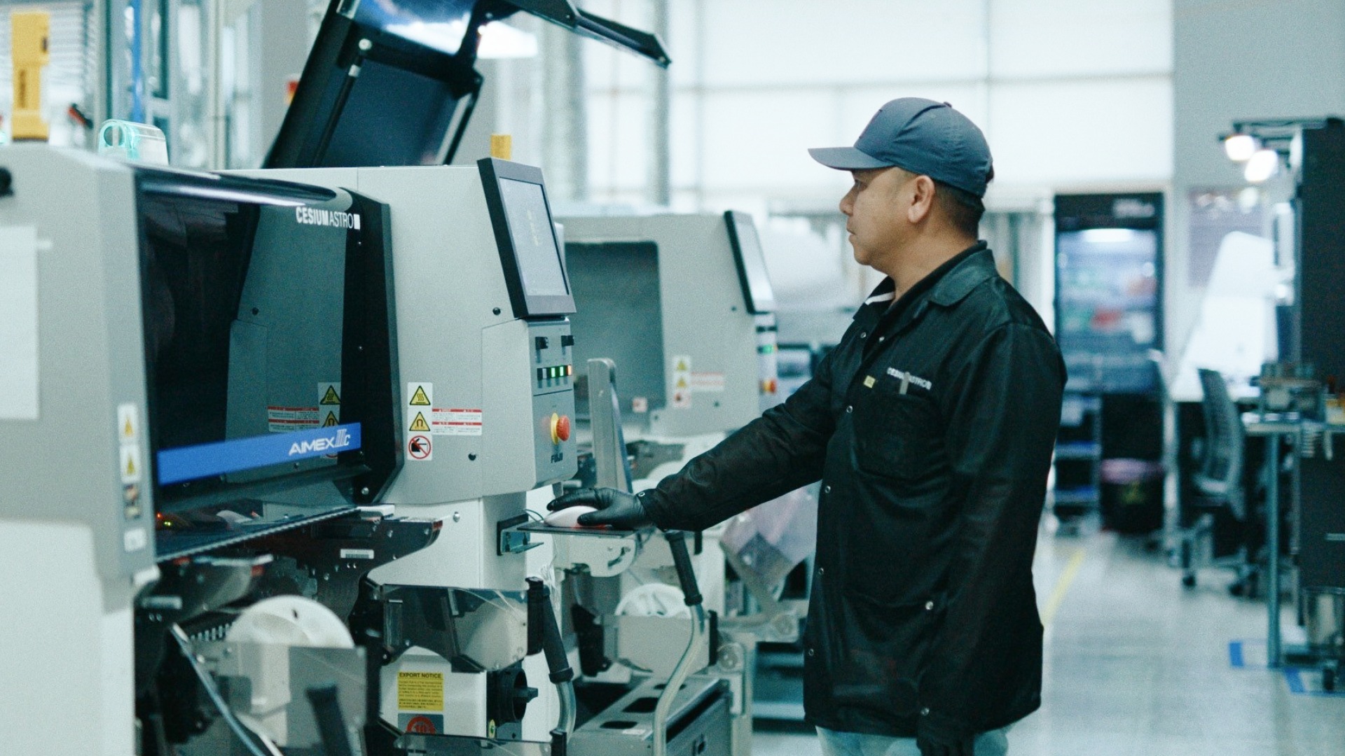 CesiumAstro employee operating electronics manufacturing equipment at the Austin production facility