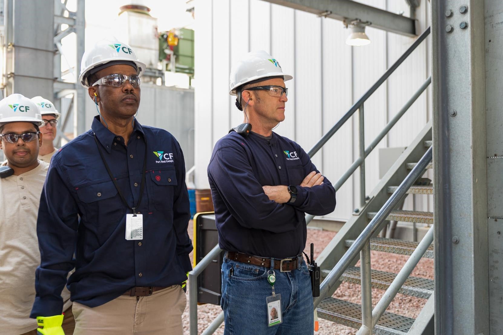 CF Industries employees wearing hard hats and protective equipment at a production site