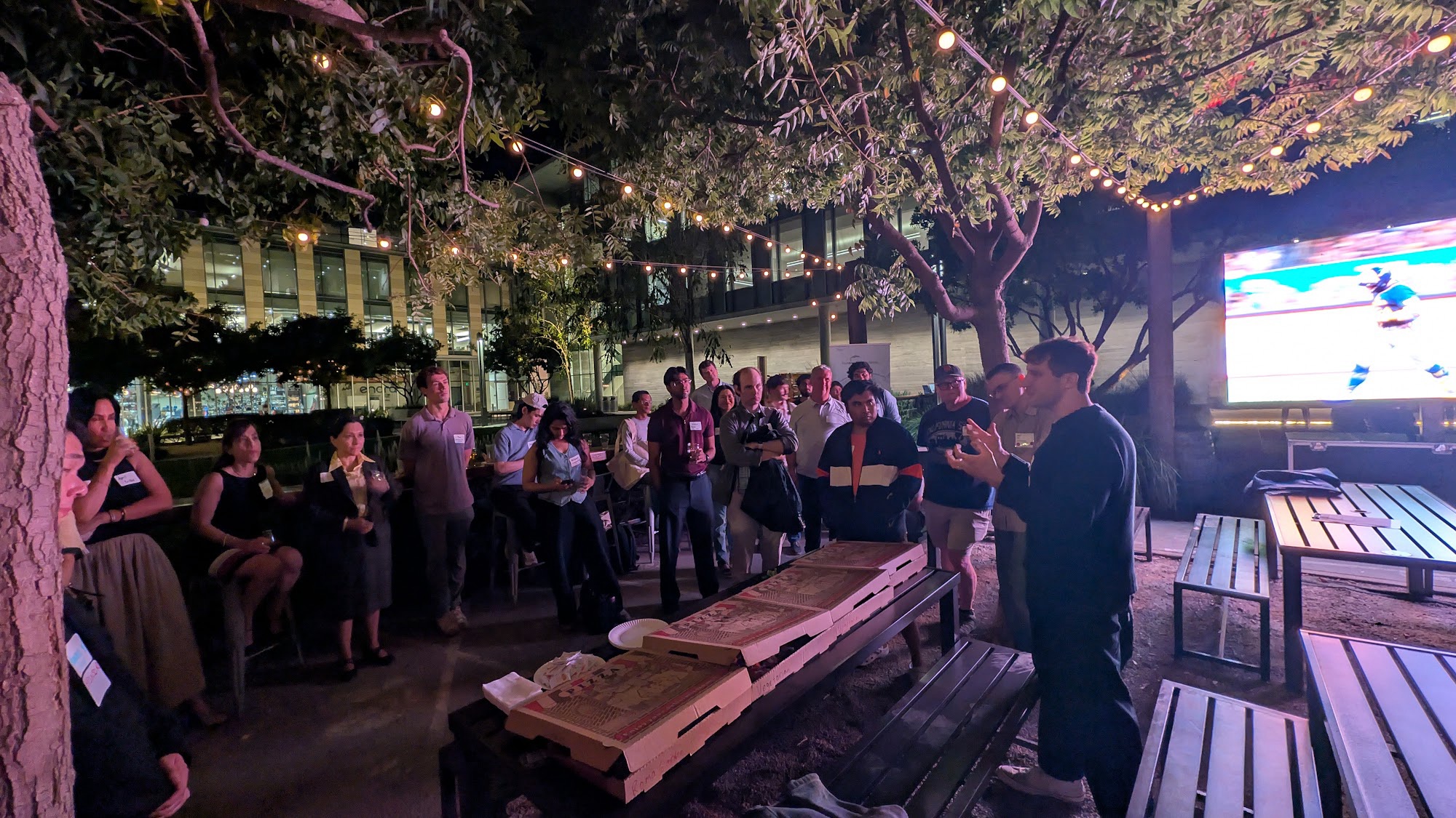 Participants gathered outdoors beneath string lights at a Chaanakya Capital SF Tech Week event