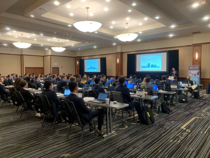 Chad Abraham speaking at the front of a Minneapolis training room filled with Piper Sandler summer interns in 2022