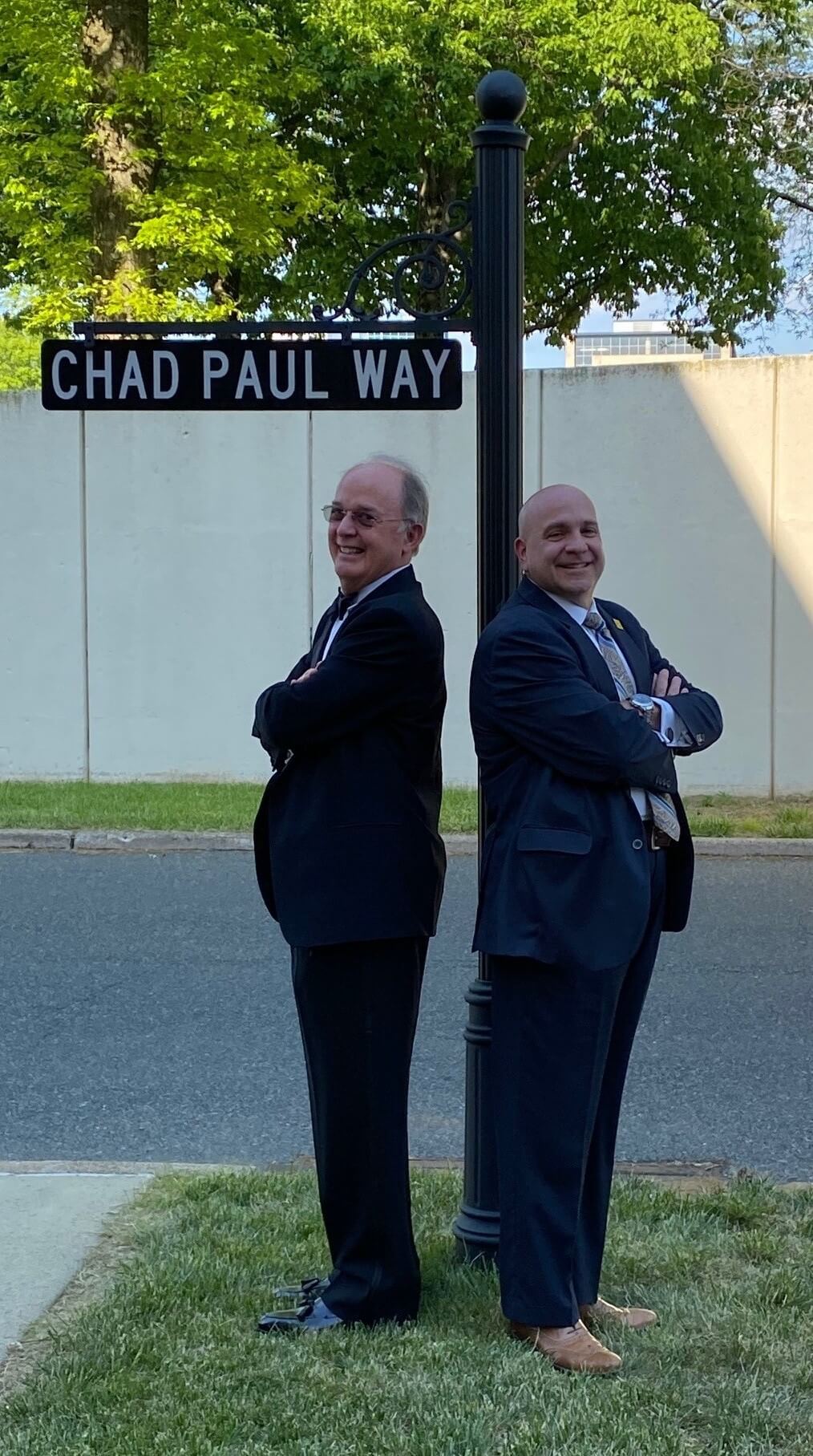 Chad Paul, left, and Angelo Valletta beside the Chad Paul Way street sign