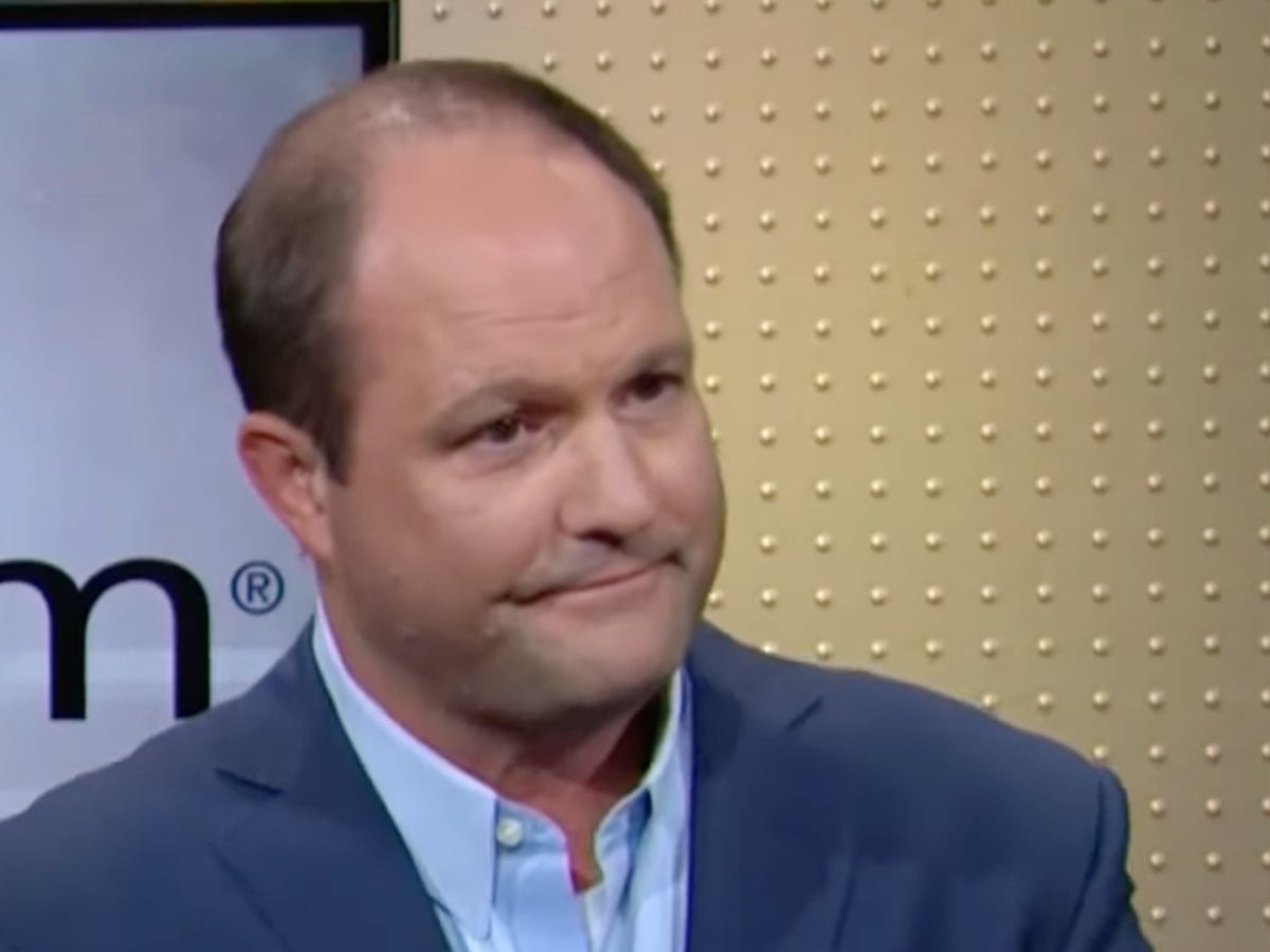 Chad Richison seated during a studio interview, wearing a blue jacket and pale blue shirt.