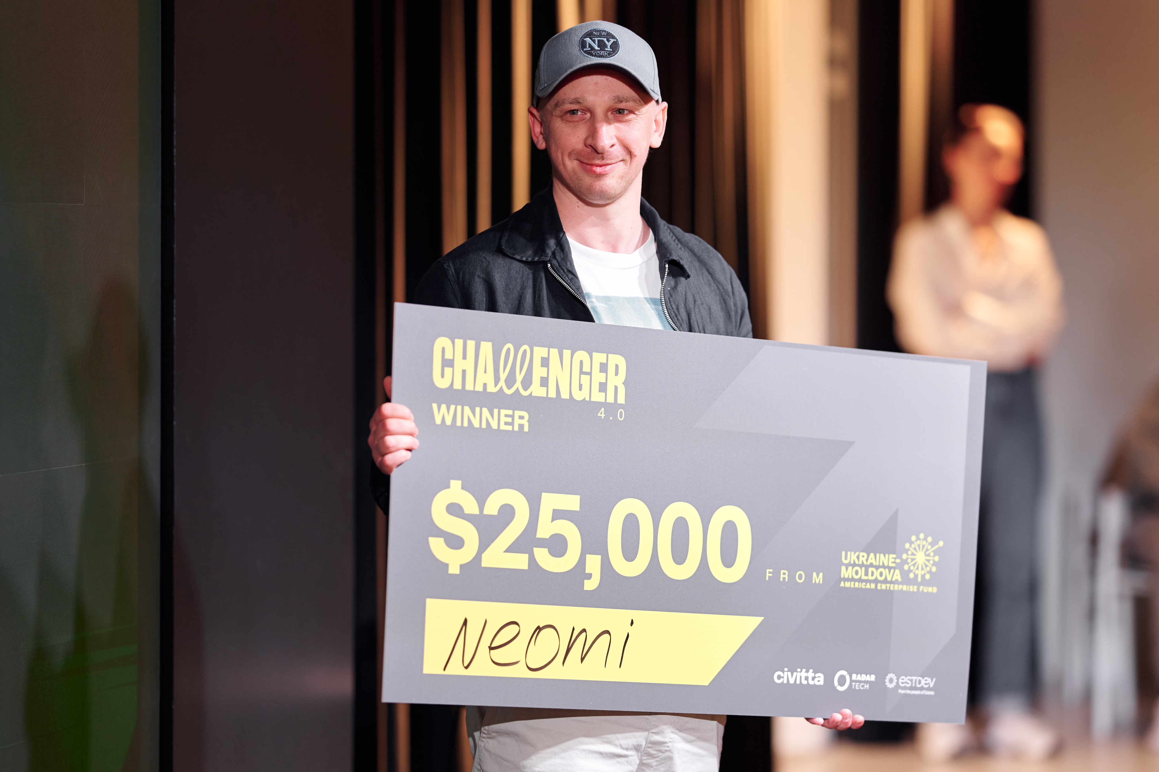 Neomi founder Dmytro Lylyk holding the Challenger 4.0 grand-prize cheque