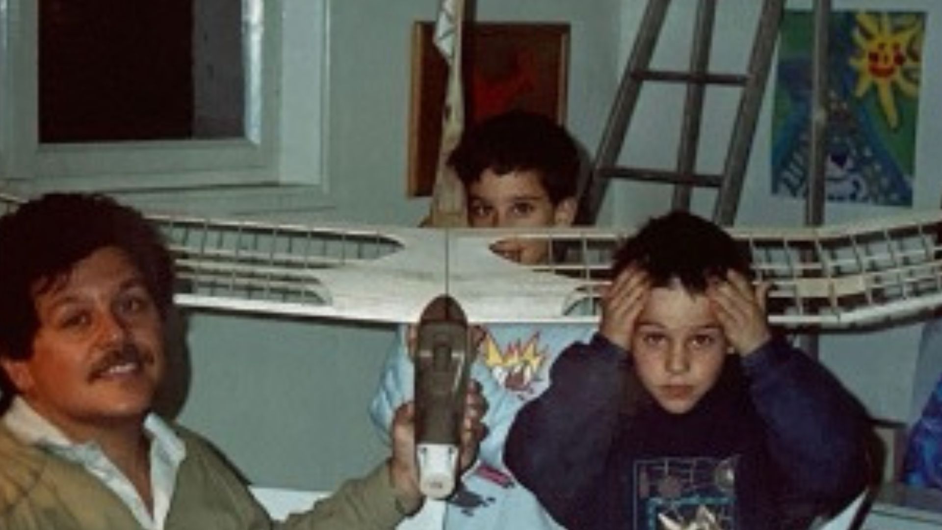 Charles Acknin as a child with his father, brother, and a model airplane under assembly