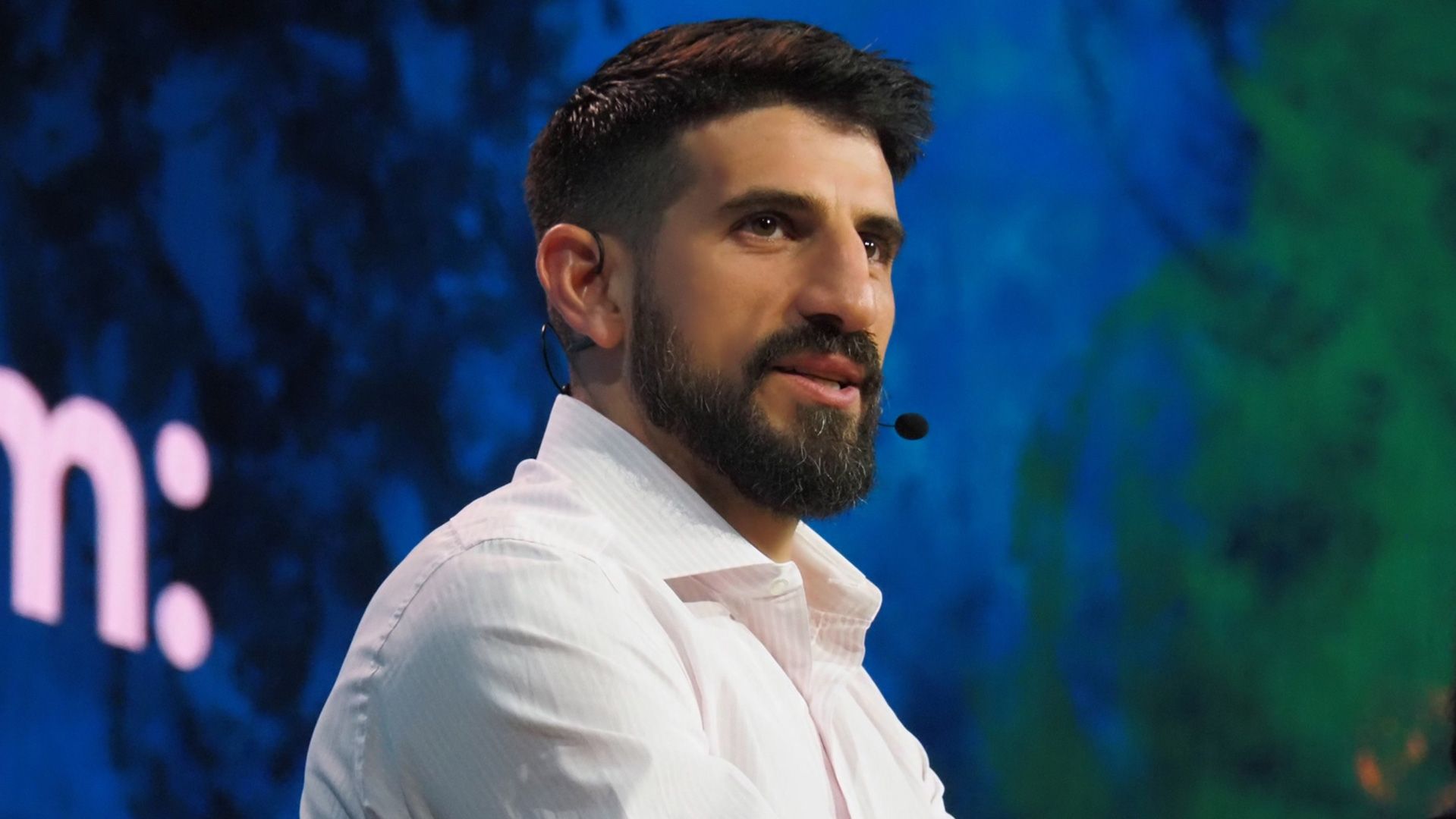 Charles Cascarilla speaking onstage, wearing a headset microphone