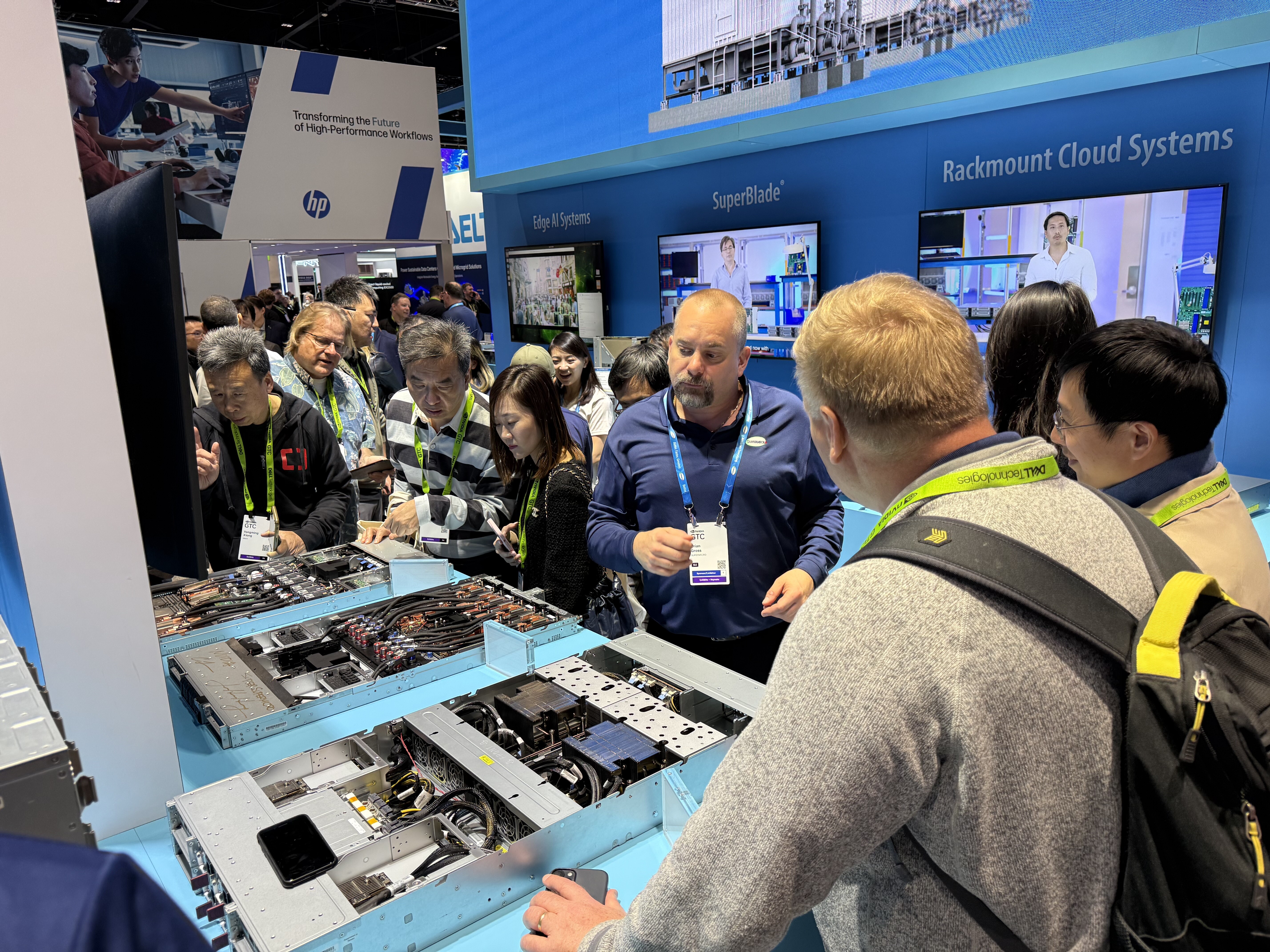 Jensen Huang and Charles Liang examining server hardware amid visitors at Supermicro’s GTC 2025 booth