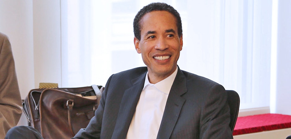 Charles Phillips smiling while seated in an open office