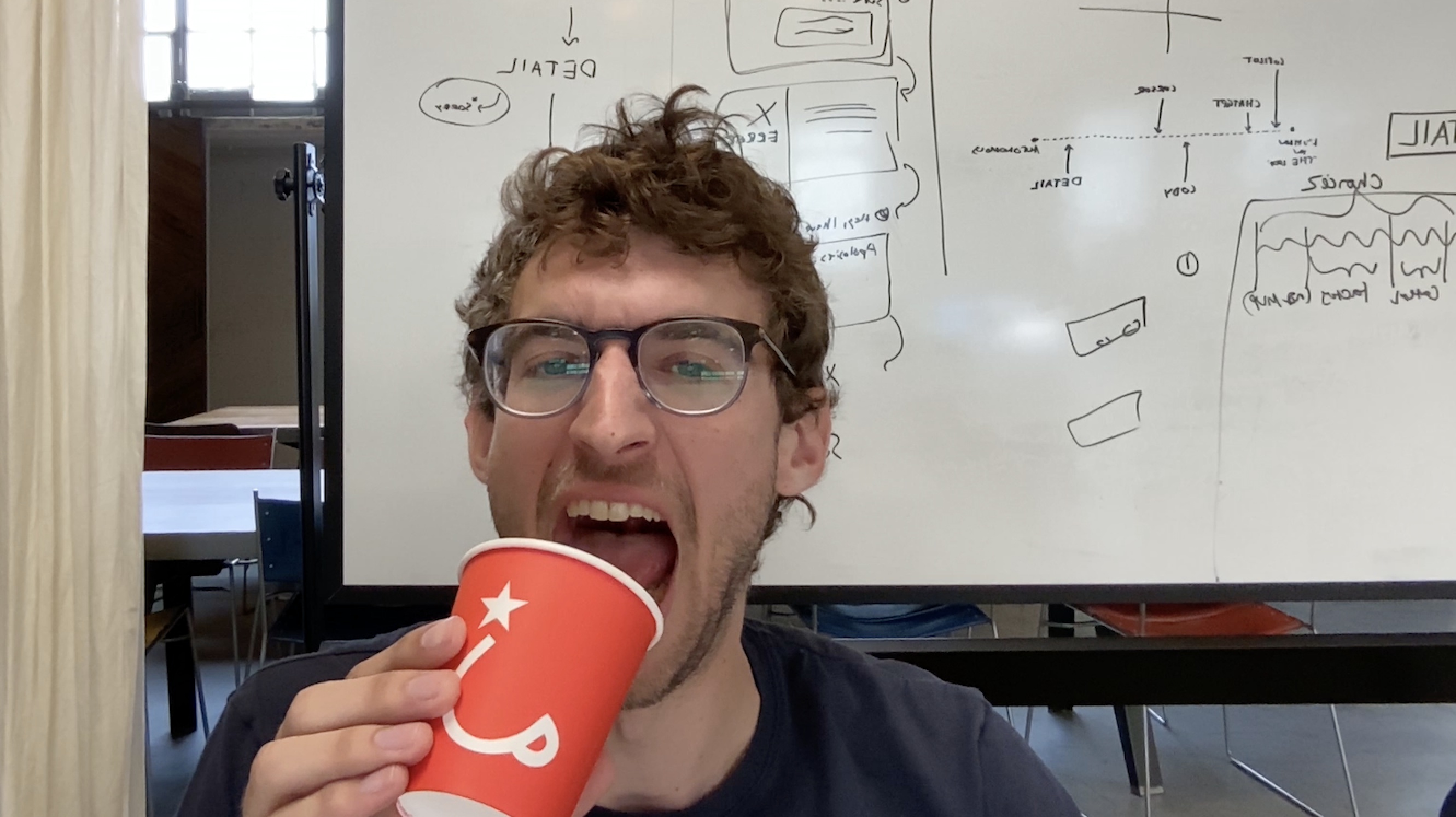 Charlie Holtz holding a red cup in a webcam image used to demonstrate his AI narrator