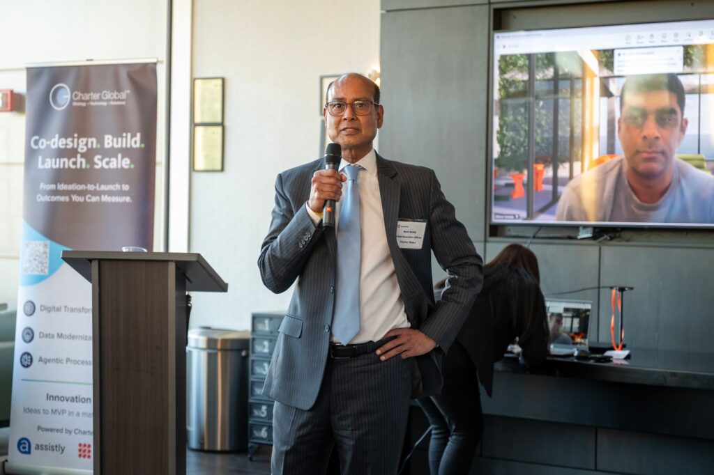 Murli Reddy speaking with a microphone at the Orcaworks launch in Atlanta