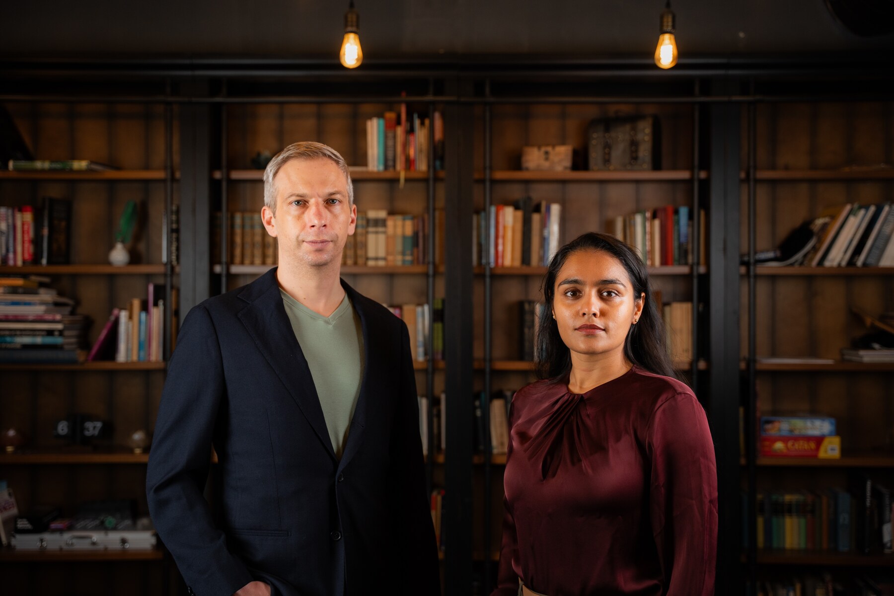 Fenrock AI cofounders Michael Mernagh and Charu Sharma standing in front of bookshelves